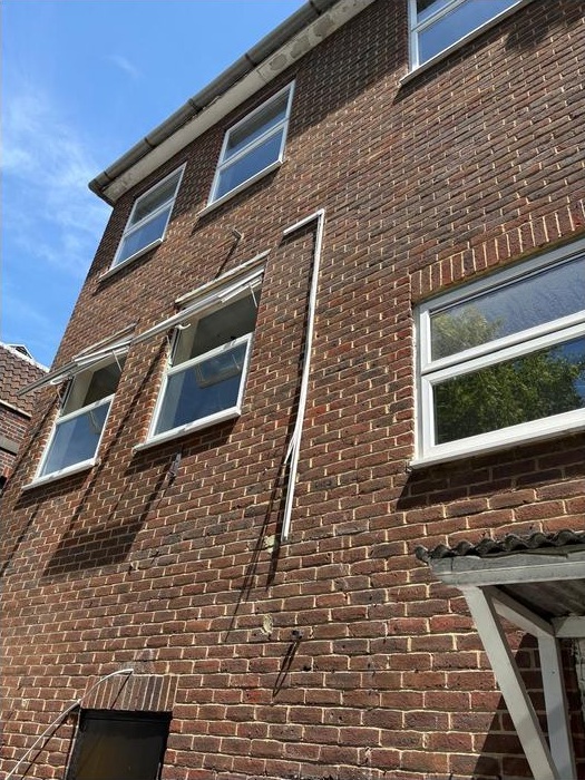Brick exterior and upper-floor windows of the New Malden building during the project.