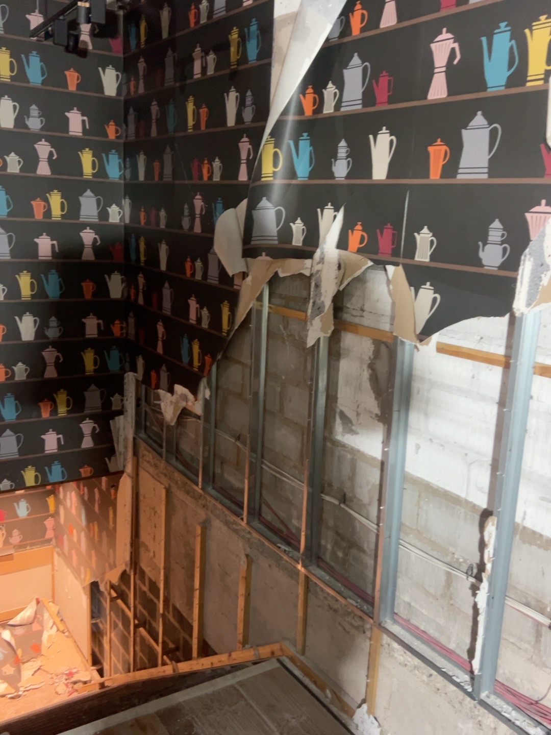 View down the staircase during strip-out at 28 Market Street, showing removed wall linings and exposed framing.