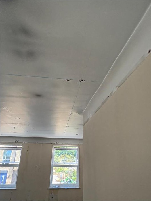Interior wall and ceiling at the New Malden site during the strip-out stage.