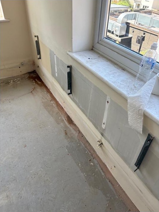 Window perimeter, exposed floor and remaining internal fittings at New Malden during the works.
