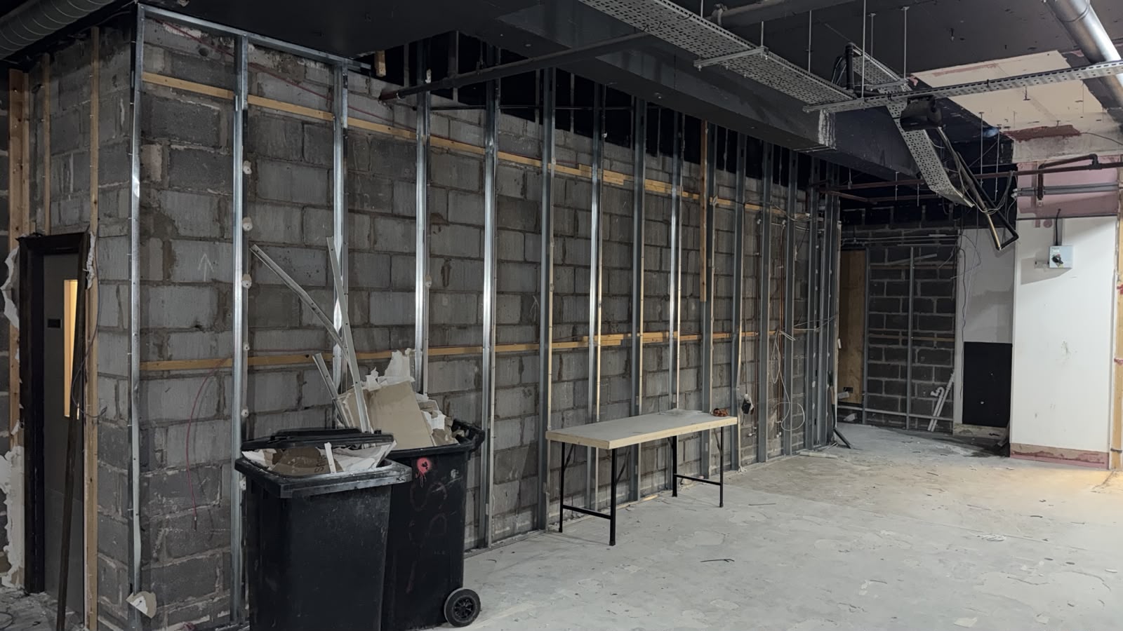 Interior of 28 Market Street during strip-out, with wall linings removed and the overhead structure visible.